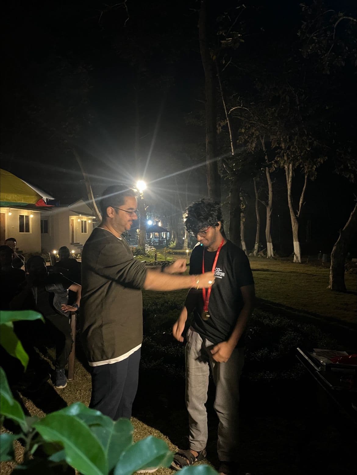 A team member receiving recognition at a Techdome offsite, after dark